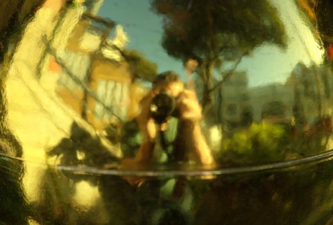 Abstract reflection of a person taking a photo, symbolizing introspection and self-awareness.