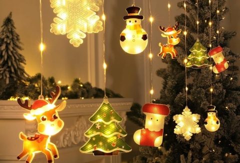 Warm Christmas lights shaped like snowflakes, trees, and holiday figures hanging near a decorated tree, creating a calm and reflective holiday atmosphere.