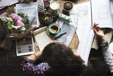 An open journal beside a cup of tea in natural light, symbolizing self-reflection, mindfulness, and the restorative practice of reading.