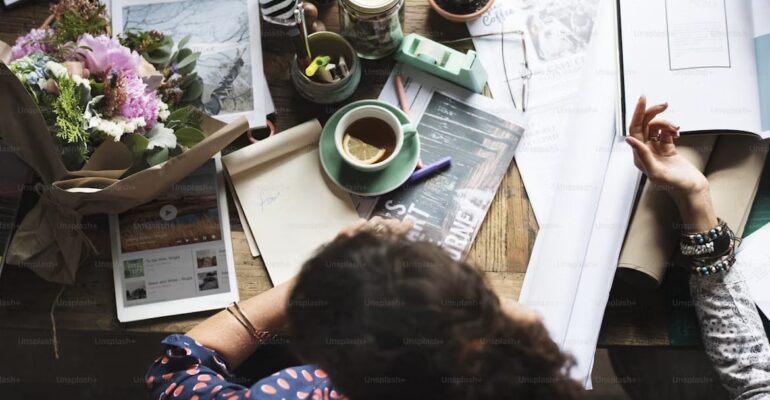 An open journal beside a cup of tea in natural light, symbolizing self-reflection, mindfulness, and the restorative practice of reading.