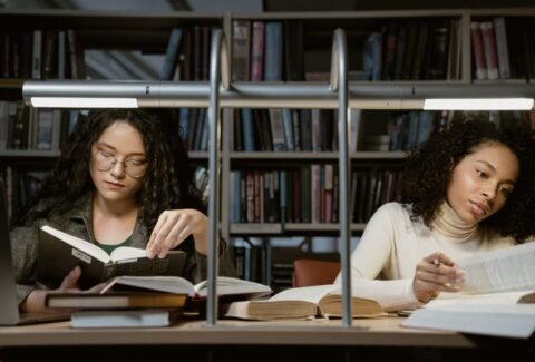Woman reading a book in a library, reflecting the quiet connection and discovery that reading can create.