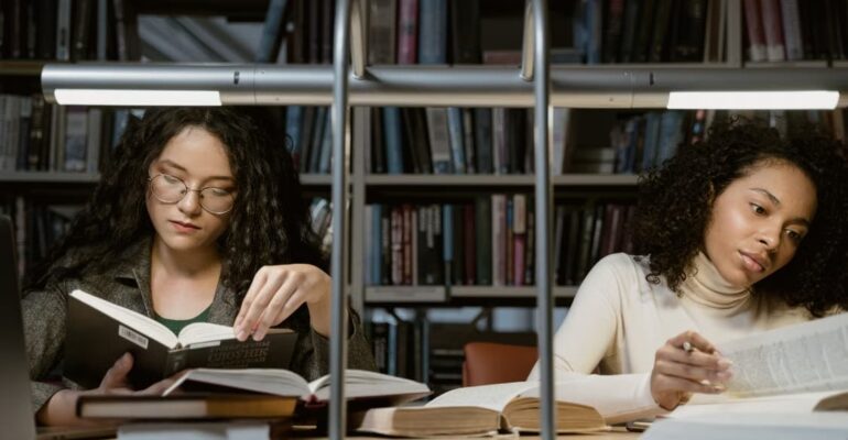 Woman reading a book in a library, reflecting the quiet connection and discovery that reading can create.